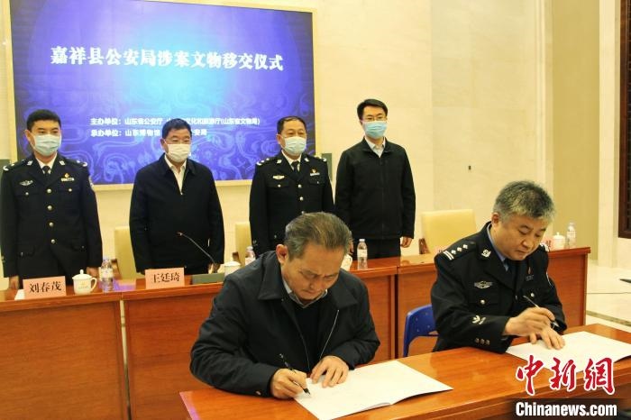 山東博物館館長(zhǎng)鄭同修和嘉祥縣人民政府副縣長(zhǎng)、公安局局長(zhǎng)趙健簽署移交協(xié)議?！≮w曉 攝