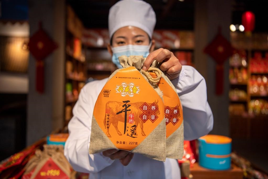 1月27日，在平遙古城南大街的一家平遙牛肉店內(nèi)，工作人員展示一款牛肉產(chǎn)品。新華社記者 楊晨光 攝