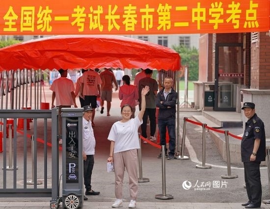 6月7日，在長(zhǎng)春市第二中學(xué)考點(diǎn)，一名考生信心滿滿進(jìn)入考場(chǎng)，并與家長(zhǎng)揮手致意。人民網(wǎng)記者 李洋攝