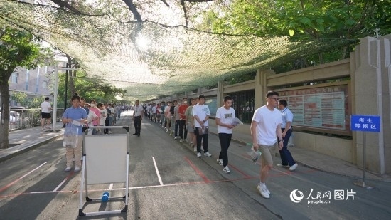 6月7日，烏魯木齊市第七十中學(xué)門口，考生們有序進(jìn)入考場(chǎng)。人民網(wǎng) 李欣洋攝