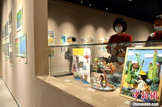 圖為家長(zhǎng)帶著孩子參觀展覽。呂明 攝