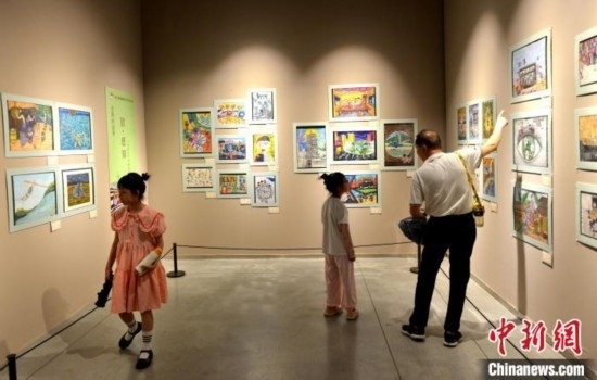 圖為家長(zhǎng)帶著孩子參觀展覽。呂明 攝