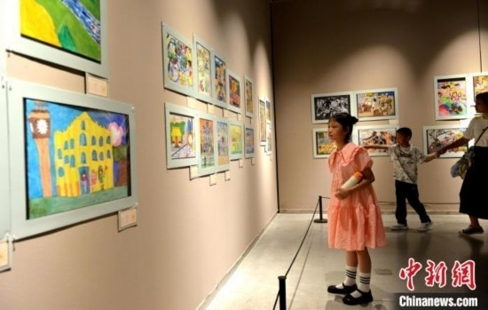 圖為家長(zhǎng)帶著孩子參觀展覽。呂明 攝