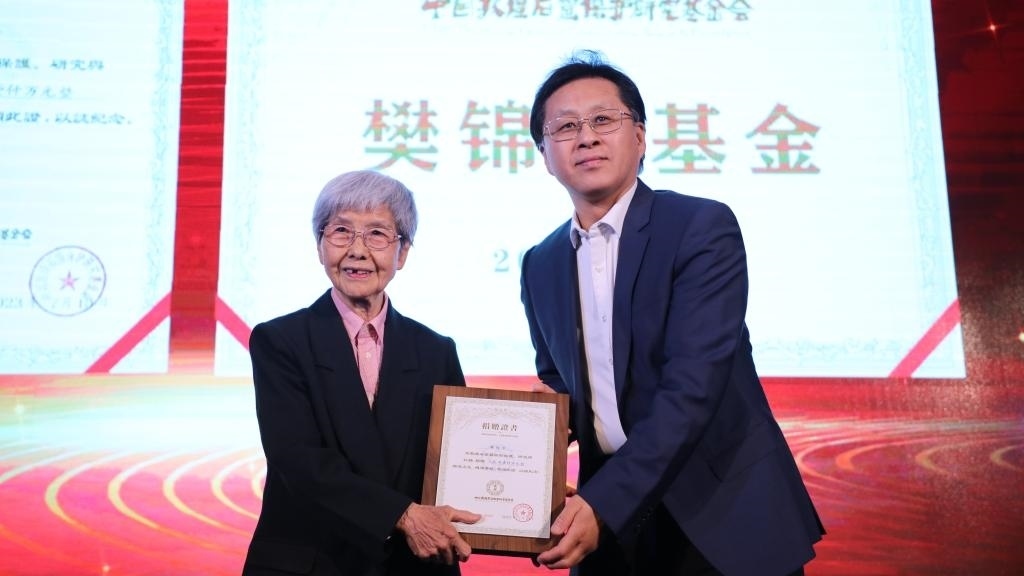 國(guó)家文物局黨組成員、副局長(zhǎng)解冰（右）為樊錦詩（左）頒發(fā)捐贈(zèng)證書。新華社記者張睿 攝