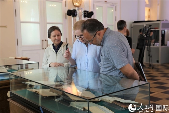 中俄圖書館論壇嘉賓共同參觀由俄羅斯國立列寧圖書館舉辦的館藏中國古籍善本圖書展。人民網(wǎng)記者 隋鑫攝