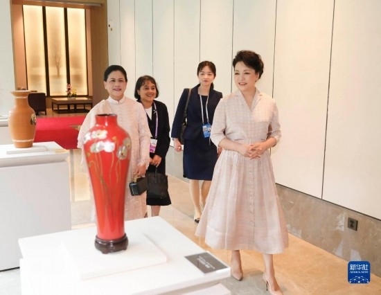 7月27日下午，國家主席習(xí)近平夫人彭麗媛在四川成都會(huì)見陪同印度尼西亞總統(tǒng)佐科來華出席第31屆世界大學(xué)生夏季運(yùn)動(dòng)會(huì)開幕式并訪華的總統(tǒng)夫人伊莉亞娜。這是彭麗媛和伊莉亞娜欣賞成都特色非遺工藝品。新華社記者 丁林 攝