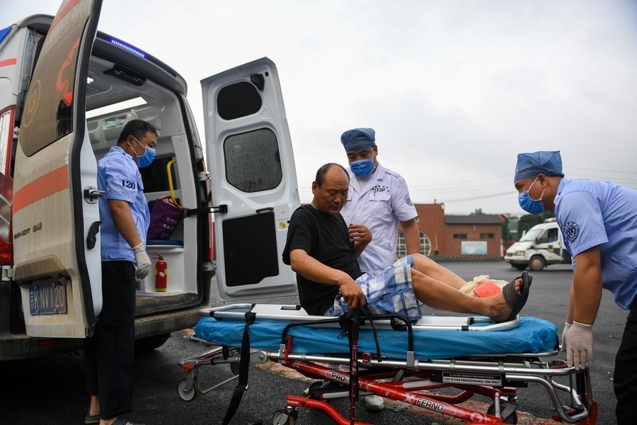 8月1日，在北京市門頭溝區(qū)妙峰山鎮(zhèn)妙峰山民族學(xué)校臨時(shí)安置點(diǎn)，北京急救中心工作人員在轉(zhuǎn)運(yùn)一名受傷村民。新華社記者 鞠煥宗 攝