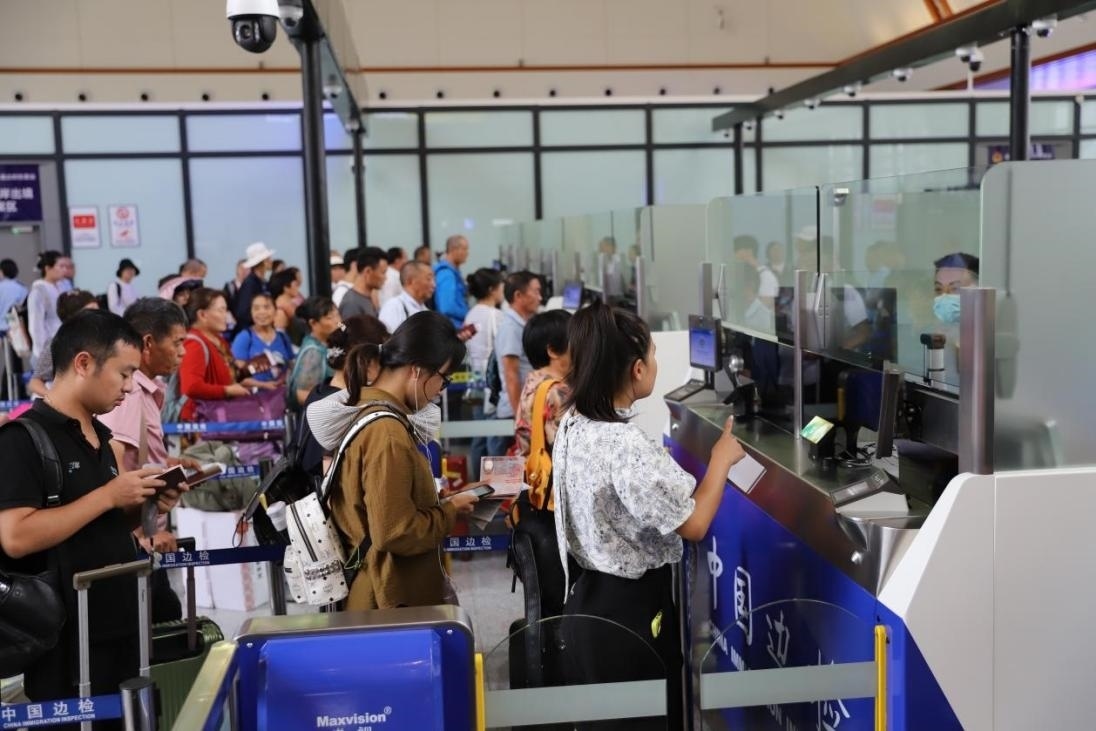 出境旅客在辦理通關(guān)手續(xù)。人民網(wǎng)記者 李發(fā)興攝