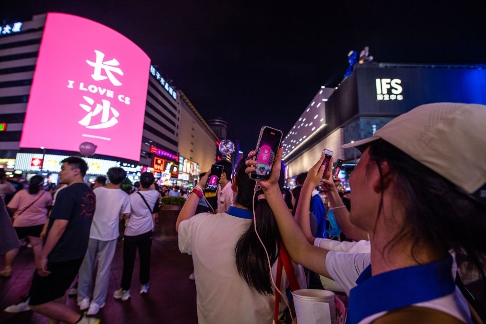  游客在長(zhǎng)沙市天心區(qū)黃興路步行街打卡、拍照（6月7日攝）。新華社記者 陳思汗 攝