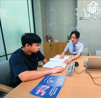 在杭州市臨安區(qū)政務(wù)服務(wù)中心的“為企服務(wù)中心”，黨員志愿者（右）解答企業(yè)主的疑問（2023年7月7日攝）。徐昱攝/本刊