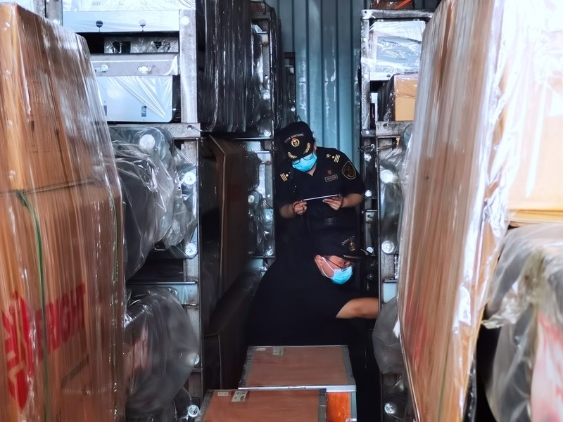 關(guān)員利用工業(yè)內(nèi)窺鏡在集裝箱內(nèi)進行查驗。人民網(wǎng)記者 栗翹楚攝