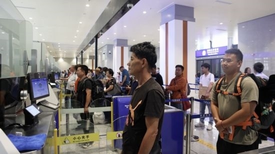 6月13日，乘坐中老鐵路國(guó)際旅客列車的旅客在磨憨邊檢大廳排隊(duì)候檢。李揚(yáng) 攝