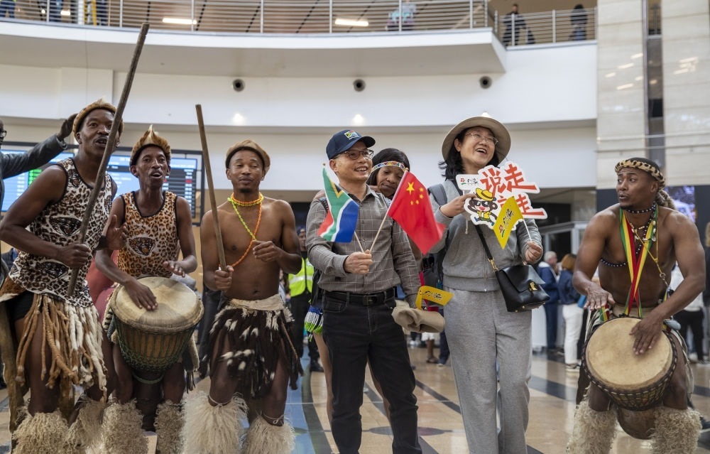 在南非約翰內(nèi)斯堡坦博國際機場，南非舞蹈演員歡迎中國試點恢復出境團隊旅游后首批抵達南非的中國游客（2023年3月29日攝）。