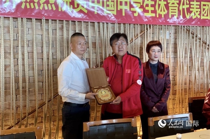 巴西中國和平統(tǒng)一促進會會長王俊曉向中國中學(xué)生體育代表團團長劉立新贈送紀念品。人民網(wǎng)記者 宋亦然攝