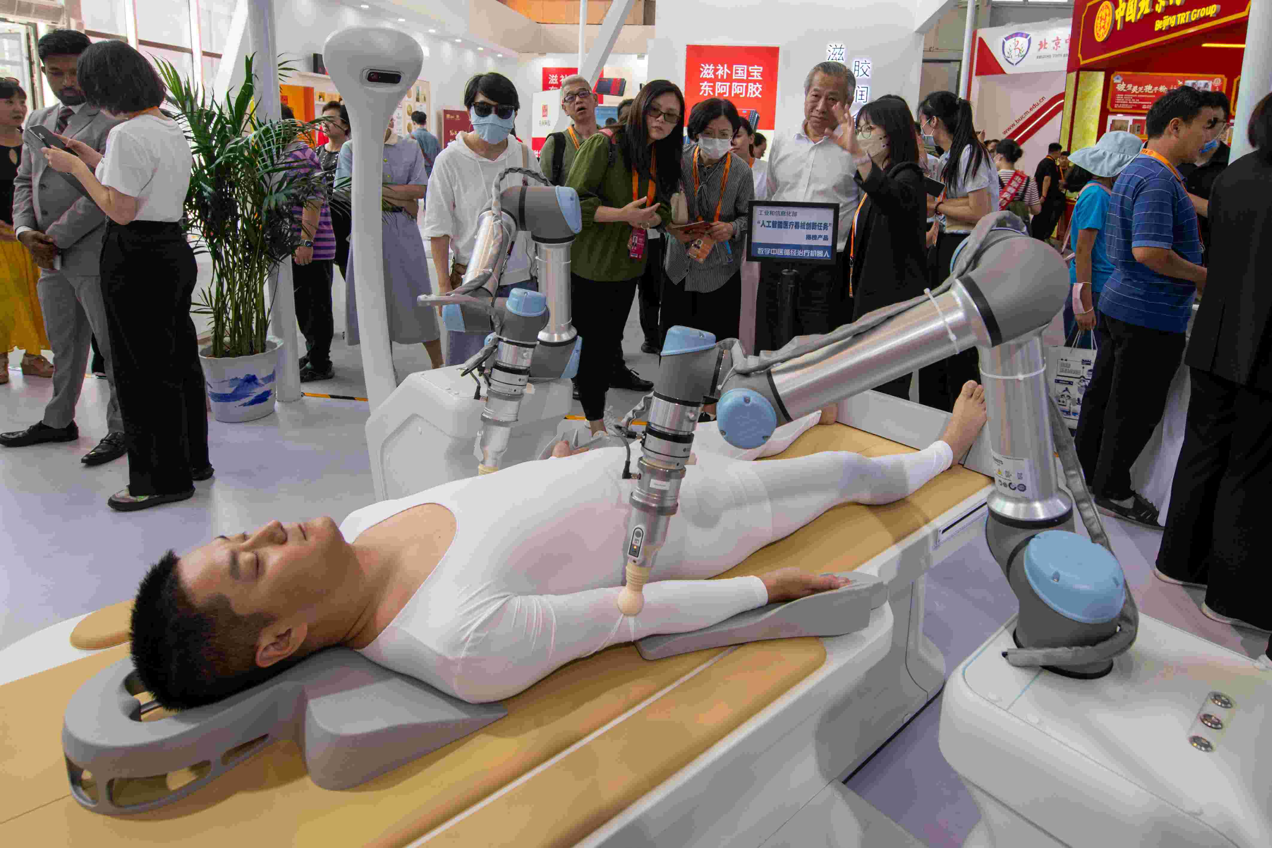 在位于首鋼園的健康衛(wèi)生服務(wù)展區(qū)，觀眾正在參觀數(shù)字中醫(yī)循經(jīng)治療機器人。人民網(wǎng)記者 翁奇羽攝
