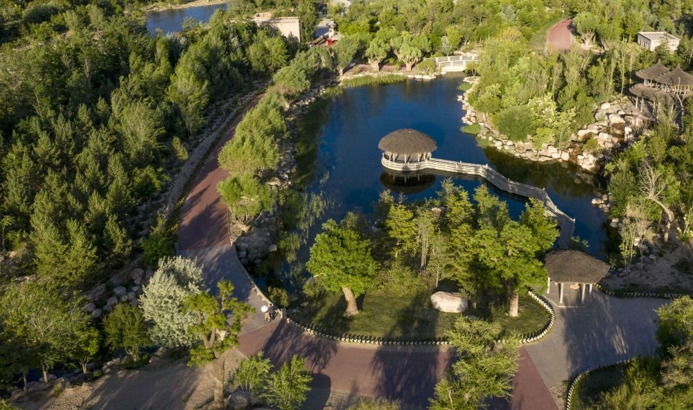 坐落在寧夏銀川市賀蘭山腳下的賀蘭山運動休閑公園（2021年5月27日攝，無人機照片）。這里曾是一片砂石采礦塌陷區(qū)，當?shù)赝ㄟ^植被景觀再造、水系建設(shè)、現(xiàn)代管網(wǎng)鋪建等手段，重新利用廢石、廢坑及各類廢棄建筑材料，把這里變成一座免費開放的主題公園。新華社記者 馮開華 攝