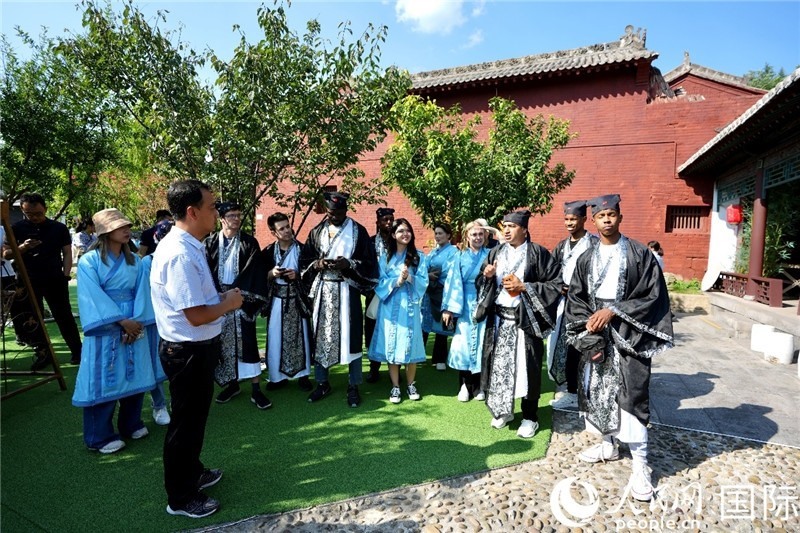 圖為選手們聽導(dǎo)游講解。人民網(wǎng) 盧鵬宇攝