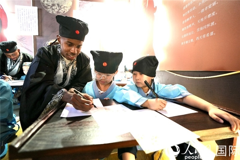 圖為選手與同學(xué)們一起寫書法。人民網(wǎng) 盧鵬宇攝