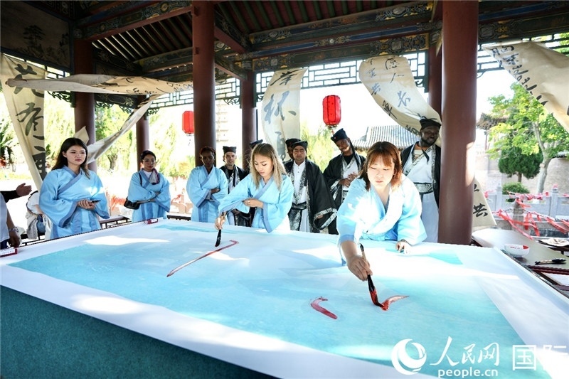 選手們提筆書寫“家園”二字。人民網(wǎng) 盧鵬宇攝