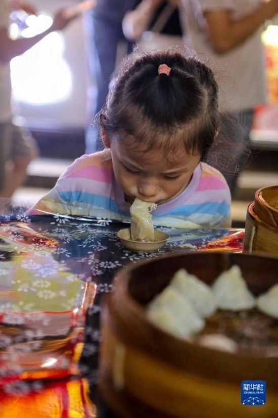 9月27日，小朋友在南翔小籠長街宴上品嘗南翔小籠。