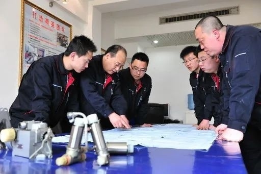 △李志強(qiáng)（左二）與班組成員在研究工作。