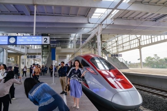  10月17日，在印度尼西亞萬隆德卡魯爾站，乘客在站臺(tái)上和雅萬高鐵高速動(dòng)車組列車合影。新華社記者 徐欽 攝
