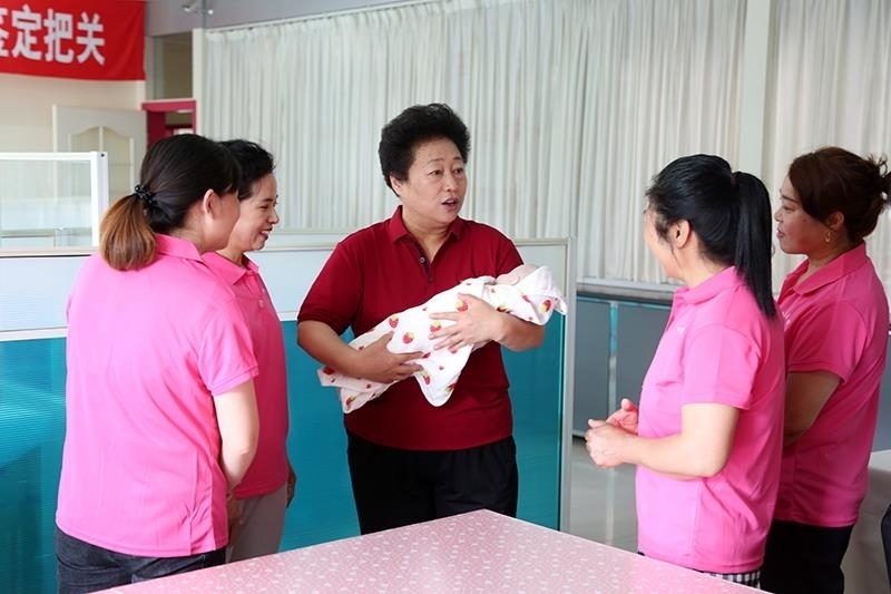 △2021年6月2日，卓長立（中）指導(dǎo)正在接受培訓(xùn)的家政服務(wù)員。