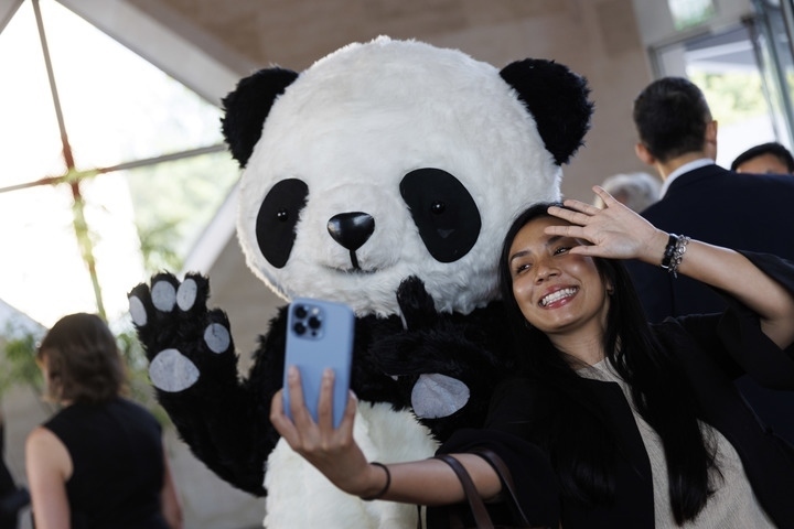 2022年8月24日，在美國(guó)華盛頓中國(guó)駐美國(guó)大使館，來(lái)賓與大熊貓玩偶合影。