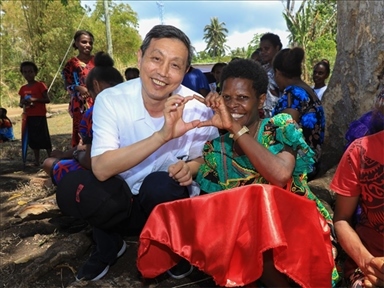 2023年12月18日，中國駐瓦努阿圖大使李名剛和前來觀看瓦努阿圖公路項目二期馬勒庫拉段移交儀式的當(dāng)?shù)鼐用窈嫌?。人民網(wǎng) 賀吉攝