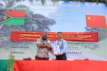 2023年12月18日，瓦努阿圖基礎(chǔ)設(shè)施和公共事業(yè)部長瑞克·查馬克·馬赫（左）和中土南太公司總經(jīng)理梁慶（右）在馬勒庫拉諾索普機(jī)場升級改造二期項目的簽約儀式上握手。人民網(wǎng) 賀吉攝