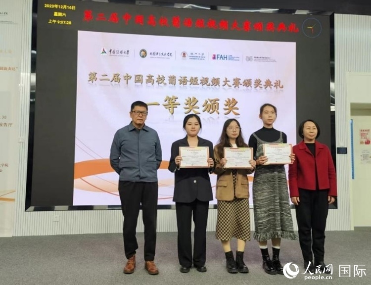 澳門大學中葡雙語教學暨培訓中心主任姚京明（左一）和中國傳媒大學外國語言文化學院院長文春英（右一）為一等獎獲得者頒獎。人民網記者 魯揚攝