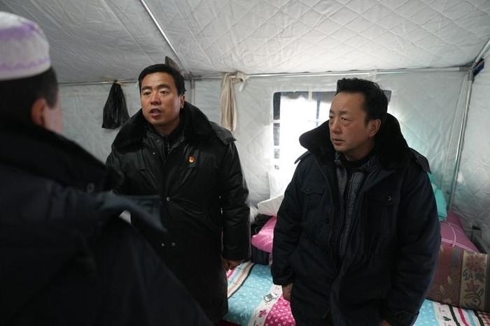 2023年12月22日，積石山縣大河家鎮(zhèn)大河村黨支部書記馬成忠（右二）在帳篷里和受災(zāi)群眾交流。新華社記者 陳斌 攝