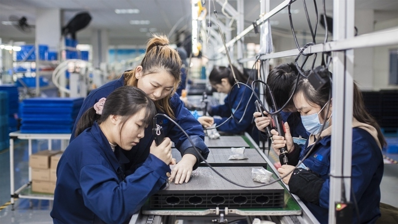 在新亞勝光電的產(chǎn)品線上，工人正進(jìn)行產(chǎn)品組建和安裝布線。受訪者供圖