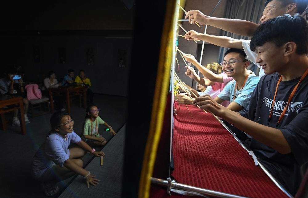 2023年8月8日，進行暑期研學的學生在位于陜西省西安市的中國秦腔藝術博物館體驗皮影戲演出。新華社記者 鄒競一 攝