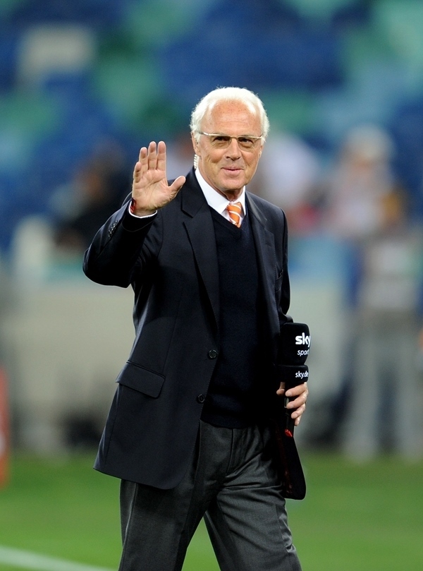 這是2010年7月7日，在南非德班舉行的2010年足球世界杯德國隊對陣西班牙隊的半決賽前，貝肯鮑爾接受電視臺采訪時和友人打招呼。新華社記者 王毓國 攝