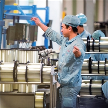 在位于武漢的長飛光纖光纜股份有限公司光纖生產(chǎn)車間內(nèi)，工作人員對光纖進(jìn)行檢測（資料圖片）。肖藝九攝/本刊