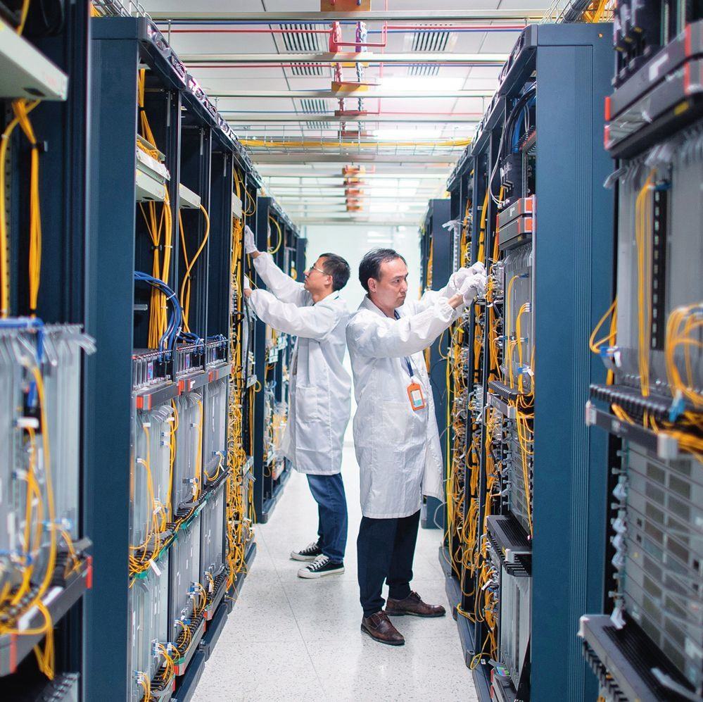 在位于武漢中國光谷的光電器件研發(fā)制造商——武漢光迅科技股份有限公司生產(chǎn)車間內(nèi)，技術(shù)人員在光模塊生產(chǎn)線作業(yè)（2023年4月11日攝）。程敏攝/本刊