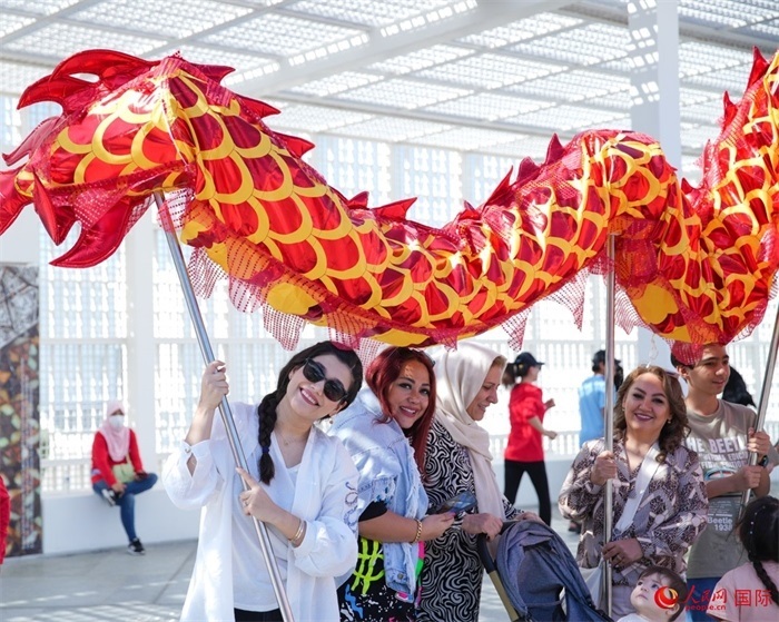 游客體驗(yàn)舞龍。 人民網(wǎng) 塔里克·易卜拉欣攝