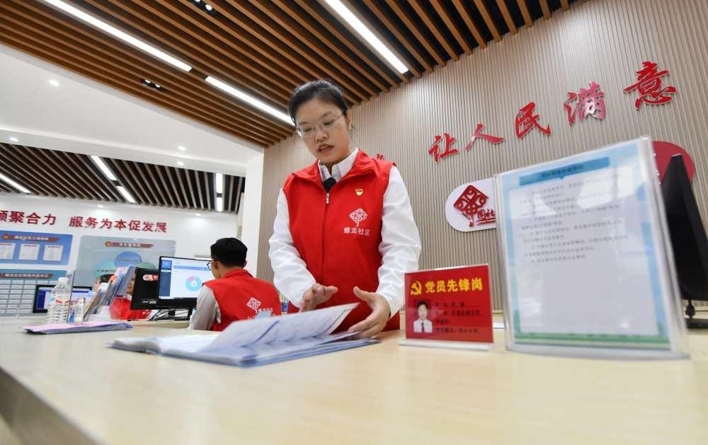 △2023年12月14日，廣西南寧市蟠龍社區(qū)，工作人員在為居民服務(wù)。