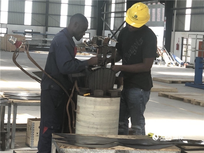 經(jīng)貿(mào)合作區(qū)廠房?jī)?nèi)，當(dāng)?shù)毓と苏诰o張作業(yè)。人民網(wǎng)記者 黃培昭攝