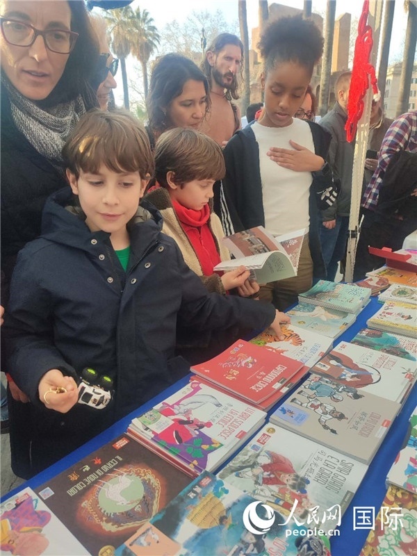 印刷精美的中國(guó)傳統(tǒng)文化叢書吸引了小游客的注意。人民網(wǎng)記者鄭彬攝