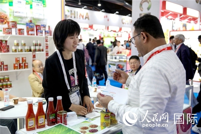 圖為中國參展企業(yè)代表與采購商交流。人民網(wǎng) 塔里克·易卜拉欣攝