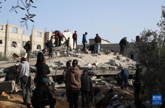  3月3日，在加沙地帶南部城市拉法，人們查看被以軍空襲破壞的建筑。新華社發(fā)（哈立德·奧馬爾攝）