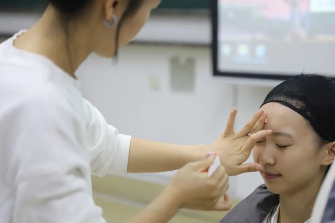 課堂上，一名學(xué)生在體驗(yàn)上戲妝。學(xué)校供圖