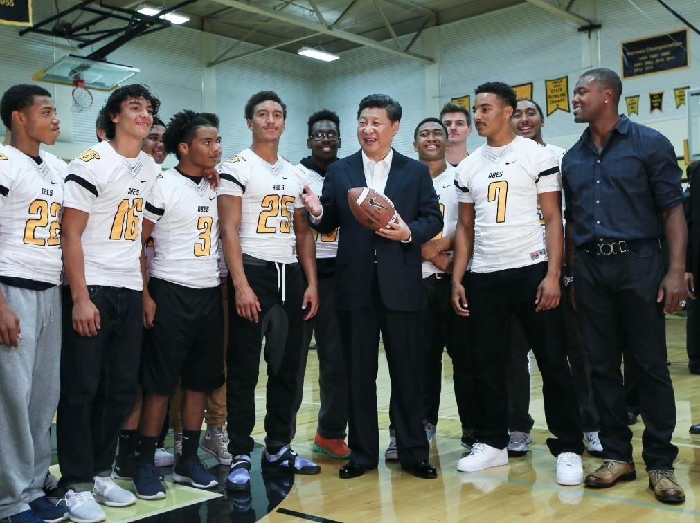 2015年9月23日，國(guó)家主席習(xí)近平參觀美國(guó)塔科馬市林肯中學(xué)。這是習(xí)近平在學(xué)校體育館，同上橄欖球訓(xùn)練課的學(xué)生們親切交談。新華社記者 蘭紅光 攝