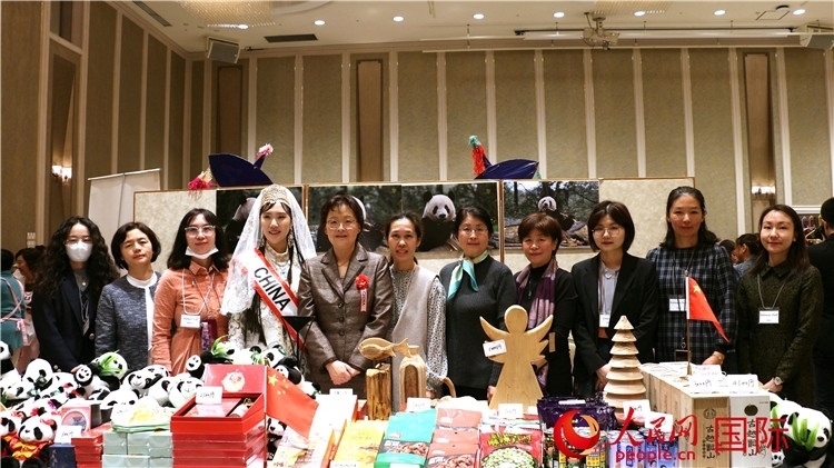 中國(guó)駐日本大使吳江浩夫人丁玥（左五）與使館人員在展位前合影留念。人民網(wǎng) 許可攝