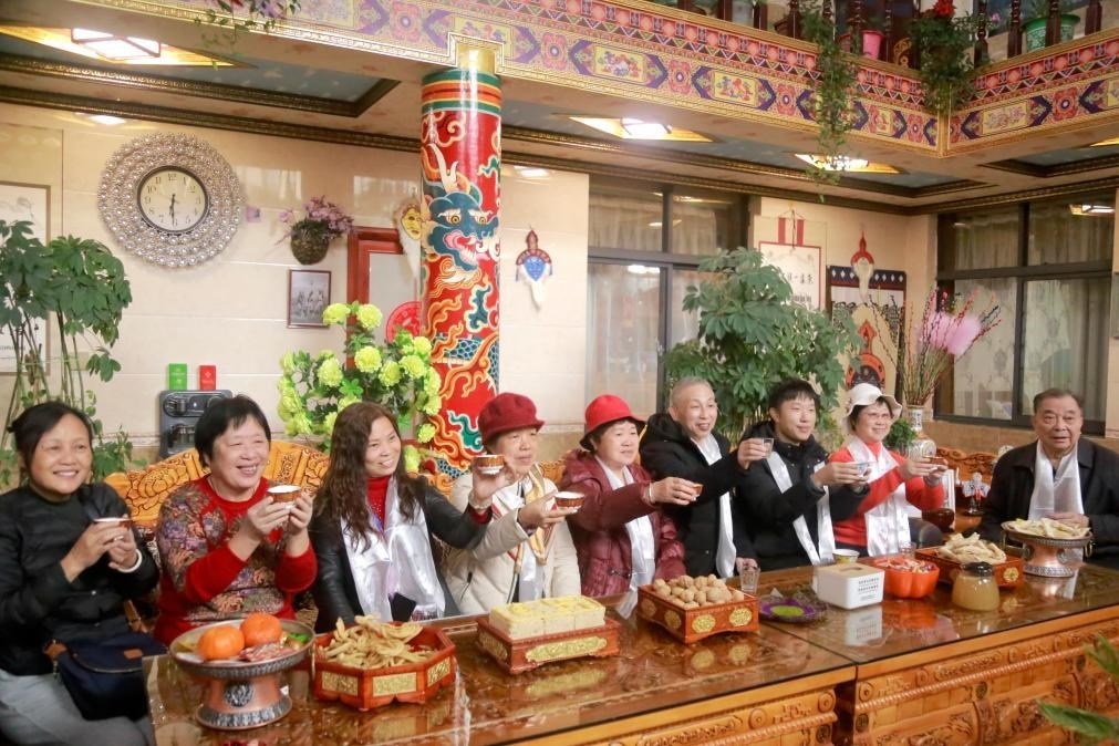 游客們?nèi)胱∶袼藓?，舉杯共飲酥油茶。新華社記者 邱星翔 攝