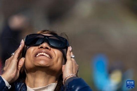 4月8日，一名女子在美國(guó)紐約州普拉茨堡觀看日食。新華社發(fā)（文森特·約翰遜攝）