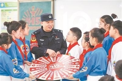 圖為公安民警給學(xué)生們講解國(guó)家安全知識(shí)。張鷹攝