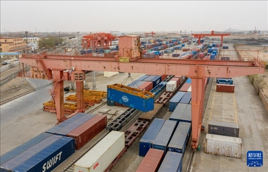 4月21日，二連浩特鐵路口岸龍門(mén)吊吊裝中歐班列集裝箱（無(wú)人機(jī)照片）。 新華社發(fā)（張海峰攝）